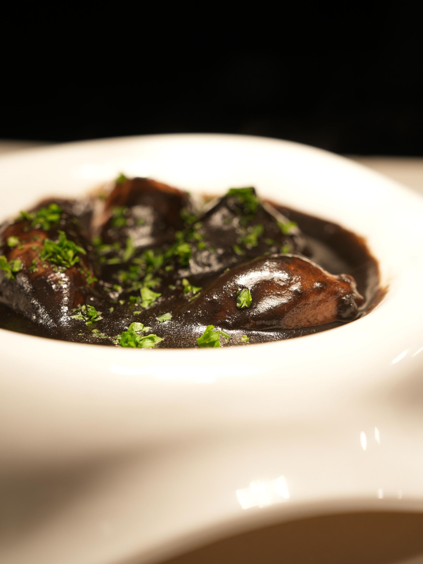 Squid braised in its own ink sauce, finished with parsley, at Madrid Tapas y Vinos